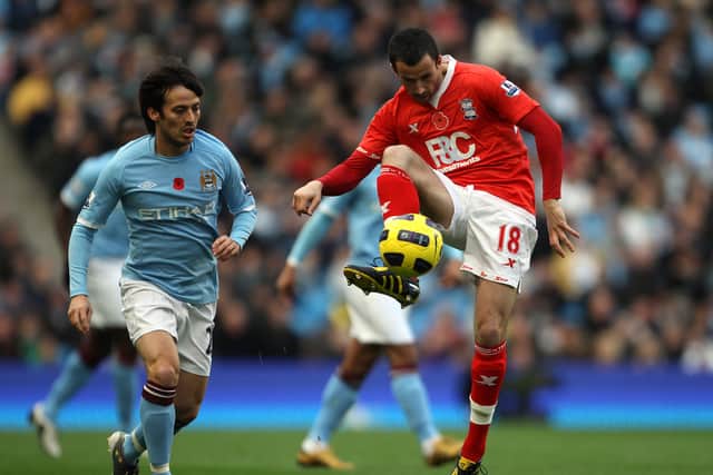 MANCHESTER, ENGLAND - NOVEMBER 13:  Keith Fahey of Birmingham City passes the ball under pressure from David Silva of Manchester City during the Barclays Premier League match between Manchester City and Birmingham City at City of Manchester Stadium on November 13, 2010 in Manchester, England.  (Photo by Alex Livesey/Getty Images)