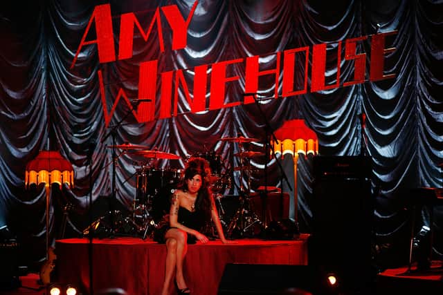 Amy Winehouse sits on stage and looks up at a television monitor whilst awaiting news of her Grammy Award at The Riverside Studios for the 50th Grammy Awards ceremony on February 10, 2008  (Photo by Peter Macdiarmid/Getty Images for NARAS)