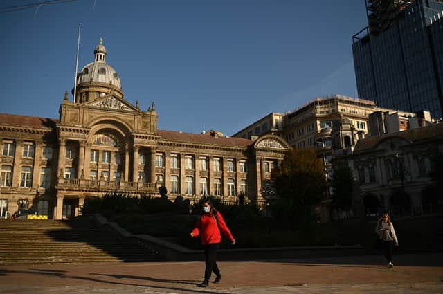 A woman wearing a face mask or covering due to the Covid-19 pandemic, walks past the town hall in Victoria Square in Birmingham (Photo by Oli SCARFF / AFP) (Photo by OLI SCARFF/AFP via Getty Images)