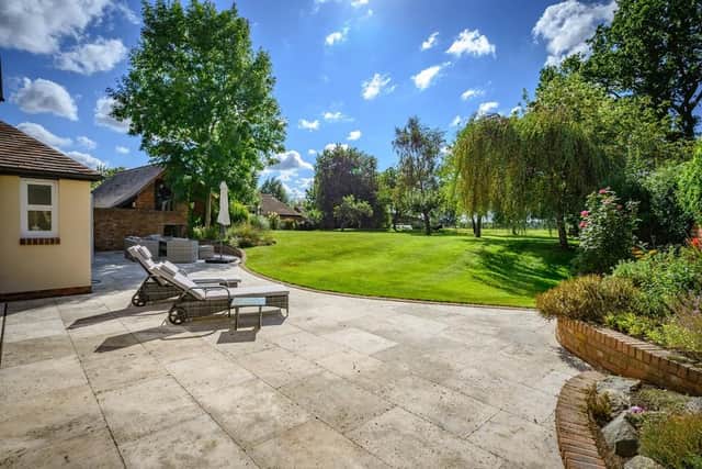 The property occupies a discrete position set behind a wide frontage with sweeping resin driveway providing ample parking and manicured lawn foregarden.