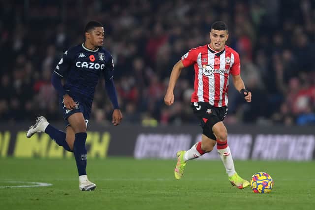 Mohamed Elyounoussi of Southampton runs with the ball whilst under pressure from Leon Bailey of Aston Villa during the Premier League match between Southampton and Aston Villa at St Mary's Stadium