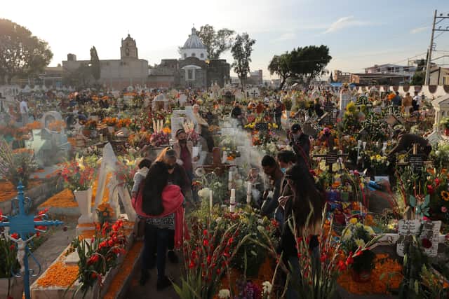 People light candles in the pantheon of San Andres Mixquic as part of the 2021 ‘Day of The Dead’ celebration on November 02 (Photo by Hector Vivas/Getty Images)