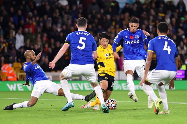 Hwang Hee-chan of Wolverhampton Wanderers is challenged by Fabian Delph and Ben Godfrey of Everton during the Premier League match between Wolverhampton Wanderers and Everton at Molineux 
