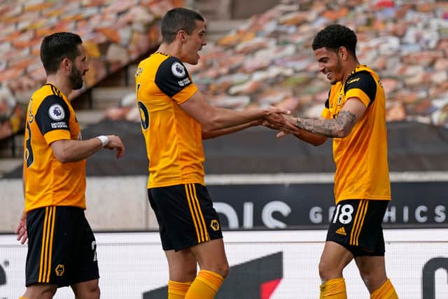 Wolverhampton Wanderers' English midfielder Morgan Gibbs-White (R) celebrates with teammates after scoring their second goal during the English Premier League football match between Wolverhampton Wanderers and Brighton and Hove Albion