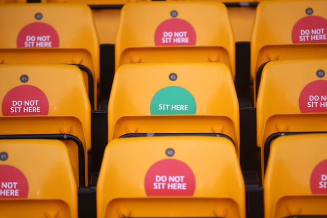 A sticker saying 'Sit Here' is seen on a seat as a social distancing measure amidst the COVID-19 Pandemic prior to the Premier League match between Wolverhampton Wanderers and West Bromwich Albion at Molineux