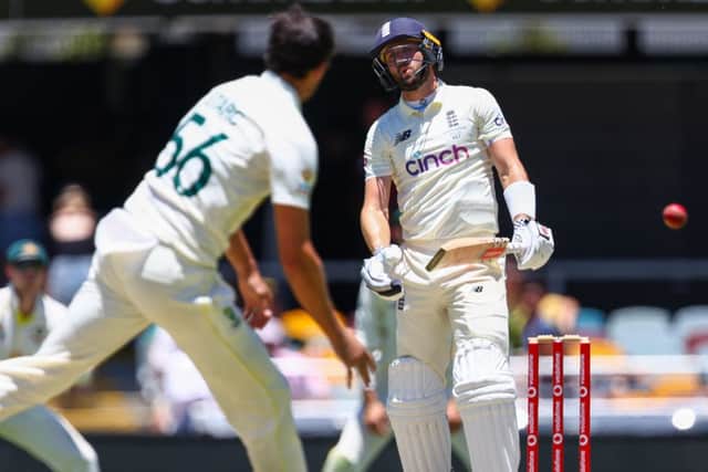 England's Chris Woakes (R) reacts to Australia's Mitchell Starc (L) during day four of the first Ashes cricket Test match between England and Australia at the Gabba in Brisbane on December 11
