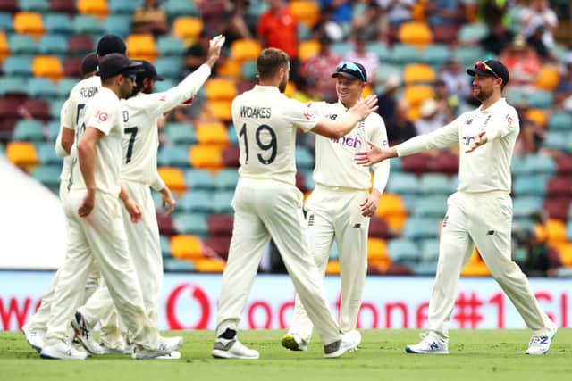  Chris Woakes of England celebrates with his team after taking the wicket of Mitchell Starc of Australia during day three of the First Test Match in the Ashes series at The Gabba