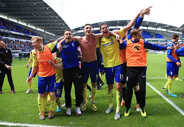 Federico Macheda (centre) celebrates with Blues team-mates after the side’s dramatic escape from relegation. Photo by Simon Stacpoole/Mark Leech Sports Photography/Getty Images