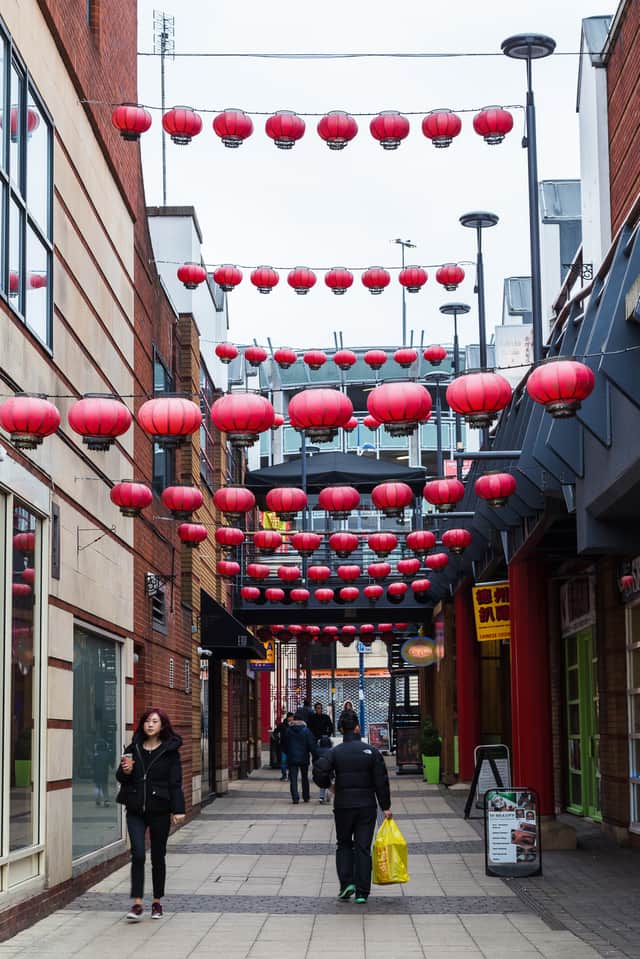 <p>Red lanterns hang above one of the narrow streets which makes up the Chinatown quarter of Birmingham</p>