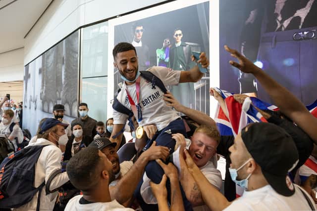Galal Yafai (Centre) of Team Great Britain is congratulated as he arrives back at Heathrow Airport on August 9, 2021 in London (Photo by Dan Kitwood/Getty Images)