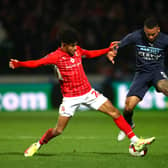 Kaine Kesler of Swindon Town tackles Gabriel Jesus of Manchester City during the Emirates FA Cup Third Round match between Swindon Town and Manchester City at County Ground