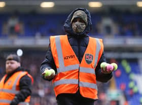 A steward picks up tennis balls thrown on the pitch by Birmingham fans in protest at the club’s owners during the match between Birmingham City and Luton Town at St Andrew’s (Photo by Alex Morton/Getty Images)