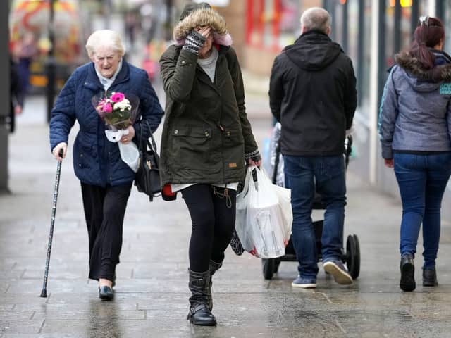 A woman pulls down her hat against the wind as the UK awaits the arrival of Storm Dudley on February 16, 2022 in Dudley (Photo by Christopher Furlong/Getty Images)