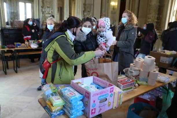 A Ukrainian refugee woman and her daughter receive foods and sanitary articles at an aid point in Budapest, Hungary. Picture: FERENC ISZA/AFP via Getty Images.
