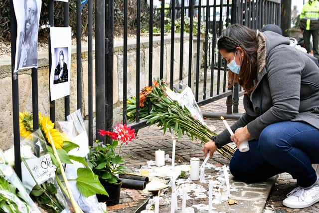 A fan lights a candle outside of the hotel where Foo Fighters' drummer Taylor Hawkins died, on March 26, 2022