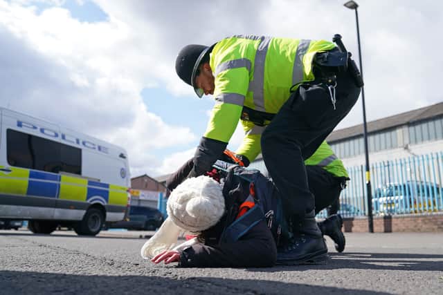 Police remove a Just Stop Oil activist taking part in a blockade of the ESSO Birmingham Fuel Terminal, Birmingham