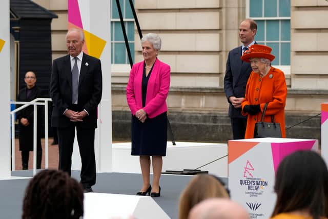 Britain’s Queen Elizabeth II (R), Louise Livingstone Martin head of the Commonwealth Games Federation (2nd L) and Prince Edward, Earl of Wessex (2nd, R) watch as the Queen’s Baton first relay runner Kadeena Cox (not pictured) starts the Queen’s Baton Relay for Birmingham 2022, the XXII Commonwealth Games, on the forecourt of Buckingham Palace on October 7, 2021 in London, England. 