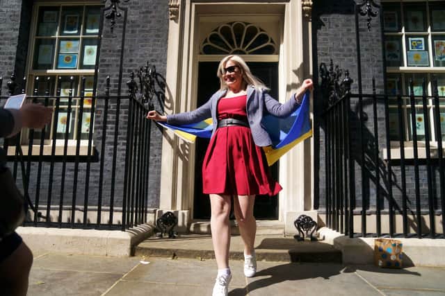 atiana Krupenko holds a Ukrainian flag on the doorstep of 10 Downing Street after visiting with her family to meet Prime Minister Boris Johnson, after her family arrived to the UK through the UK visa scheme. Picture date: Friday May 13, 2022.