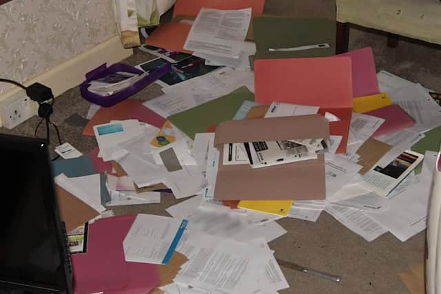 Mr Varlow's ransacked house with papers strewn on the floor