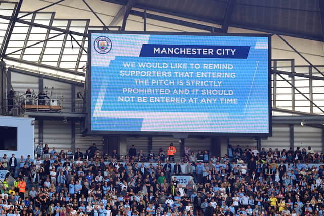 The LED board shows a message to prevent fans from invading the pitch during the Premier League match between Manchester City and Aston Villa at Etihad Stadium