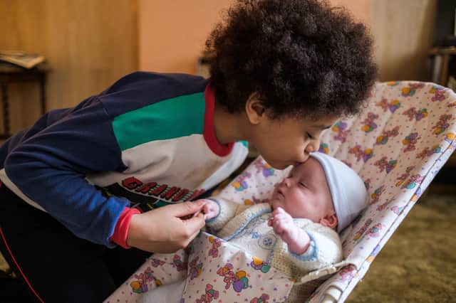 Cole Martin as Leon in My Name is Leon, kissing his baby brother on the forehead (Credit: Ben Gregory-Ring/BBC/Douglas Road Productions)