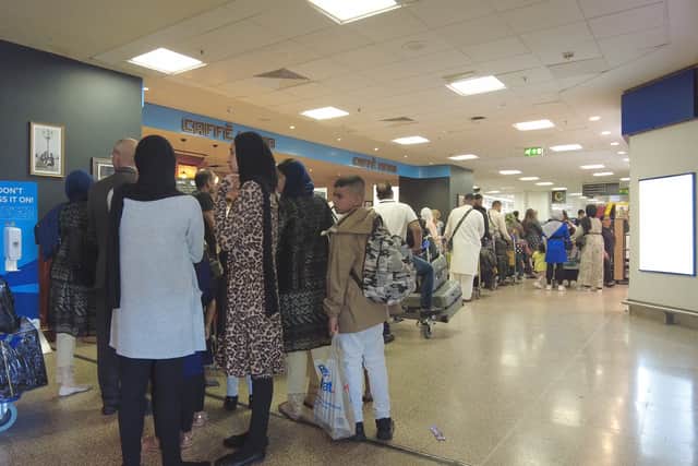 Passengers queue at Birmingham Airport