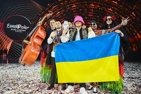 Members of the band "Kalush Orchestra" pose onstage with the winner's trophy and Ukraine's flags after winning on behalf of Ukraine the Eurovision Song contest 2022 