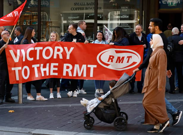<p>Rail workers stand on a picket line during the RMT strike on 27 July 2022</p>