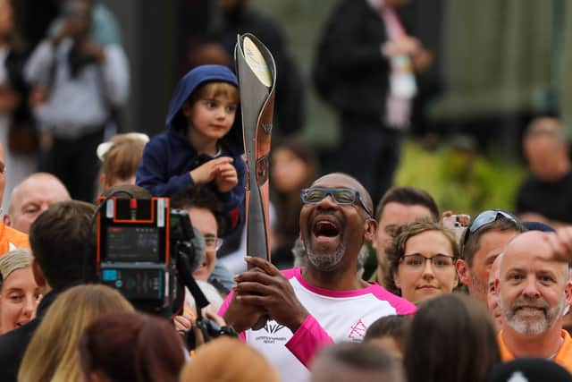 Comic Relief founder Sir Lenny Henry carries the Birmingham 2022 Queen's Baton at Victoria Square Birmingham