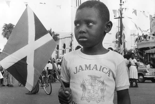 A boy holding the new Jamaican flag and wearing a commemorative tee-shirt at the Independence celebrations. 