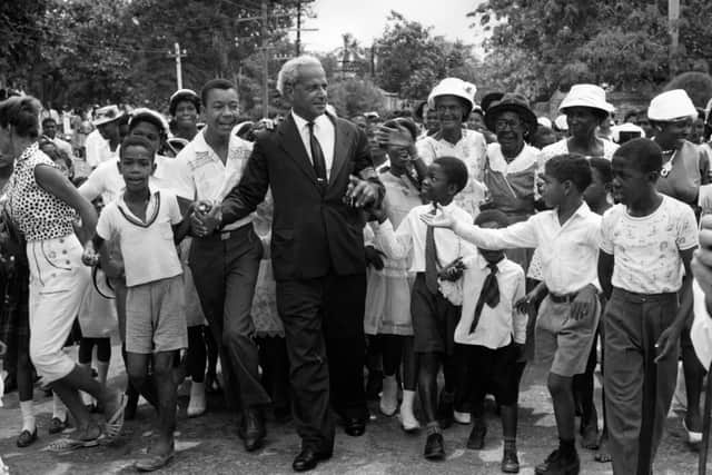  Children gather round Norman W Manley (1893-1969), founder of the Jamaican People's National Party, as he makes his way to the cathedral for Jamaica's Independence Day celebrations