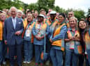 Prince Charles, Prince of Wales poses for pictures with Commonwealth Games volunteers during a visit to the Athletes Village at The University of Birmingham