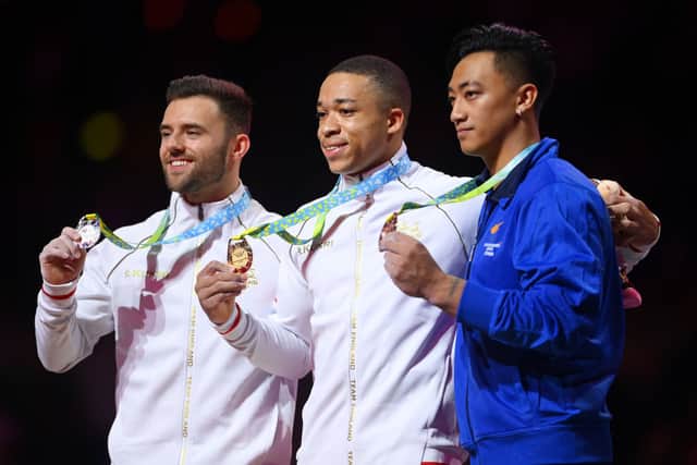 : (L-R) Silver medalist Giarnni Regini-Moran of Team England, gold medalist Joe Fraser of Team England and bronze medalist Marios Georgiou of Team Cyprus pose for a photo during the medal ceremony for Men's Parallel Bars Final on day five of the Birmingham 2022 Commonwealth Games at Arena Birmingham