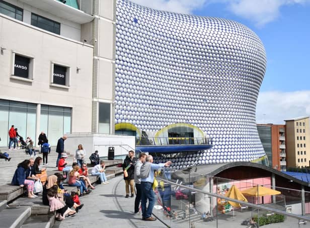 <p>People sit outside the Bullring shopping centre in Birmingham. (Photo by JUSTIN TALLIS/AFP via Getty Images)</p>