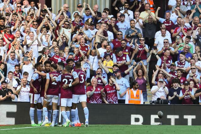 Aston Villa's English striker Danny Ings (unseen) celebrates with teammates and supporters after scoring his team first goal during the English Premier League football match between Aston Villa and Everton at Villa Park