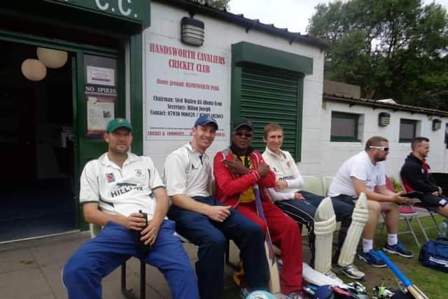 Trevor McIntosh (in red) with cricketers at the club