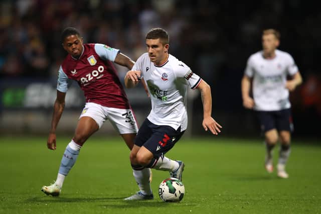 Declan John of Bolton Wanderers competes for the ball with Leon Bailey of Aston Villa during the Carabao Cup Second Round match between Bolton Wanderers and Aston Villa at University of Bolton Stadium