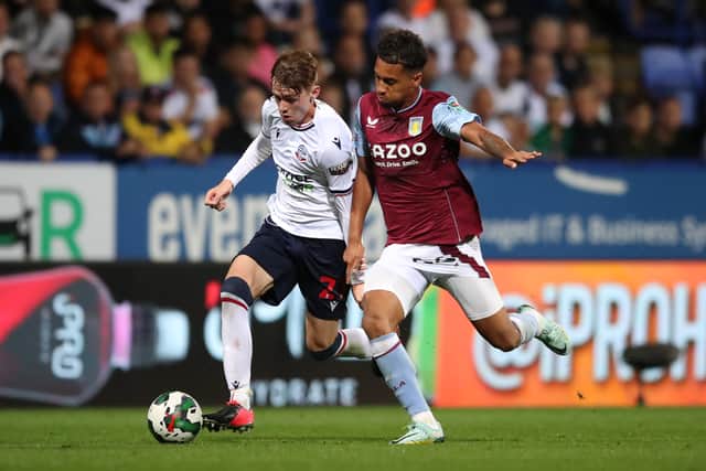 Conor Bradley of Bolton Wanderers battles with Boubacar Kamara of Aston Villa during the Carabao Cup Second Round match between Bolton Wanderers and Aston Villa at University of Bolton Stadium