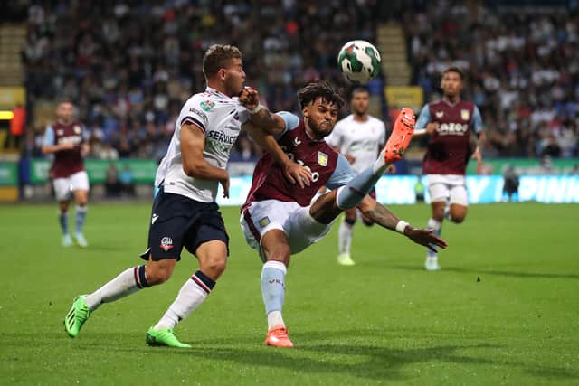 Tyrone Mings of Aston Villa battles with Dion Charles of Bolton Wanderers during the Carabao Cup Second Round match between Bolton Wanderers and Aston Villa at University of Bolton Stadium