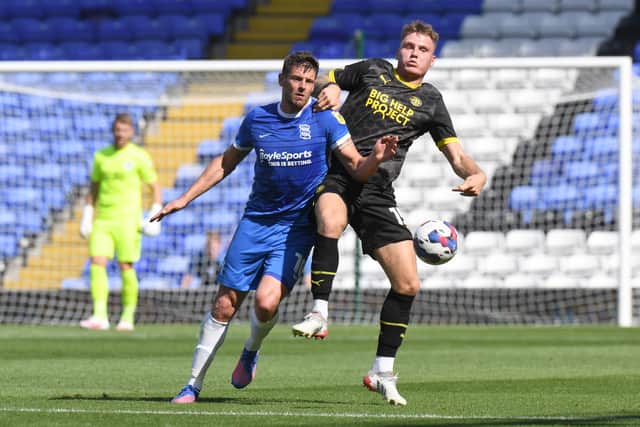 Lukas Jutkiewicz of Birmingham City is challenged by Jason Kerr of Wigan Athletic during the Sky Bet Championship match between Birmingham City and Wigan Athletic at St Andrews