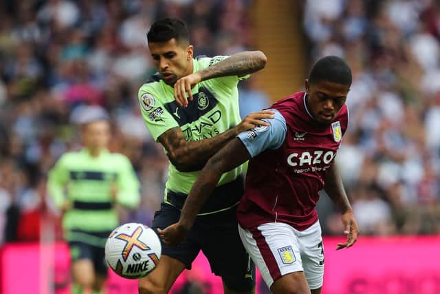 Manchester City's Portuguese defender Joao Cancelo (L) fights for the ball with Aston Villa's Jamaican striker Leon Bailey during the English Premier League football match between Aston Villa and Manchester City at Villa Park