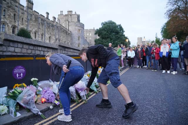Mourners gather laying flowers outside Windsor Castle in Berkshire following the announcement of the death of Queen Elizabeth II. Picture date: Thursday September 8, 2022.