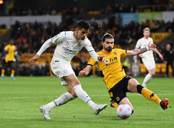 Ruben Neves of Wolverhampton Wanderers makes a sliding challenge on Joao Cancelo of Manchester City the last time the two sides met at Molineux.
