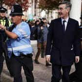 Police officers hold back members of the public as Jacob Rees-Mogg arrives (PA)