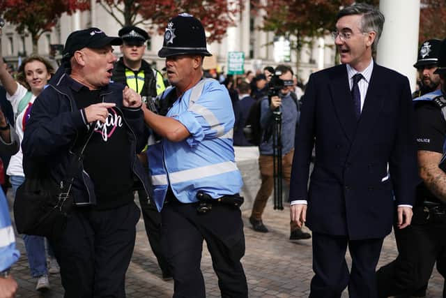 Police officers hold back members of the public as Jacob Rees-Mogg arrives (PA)