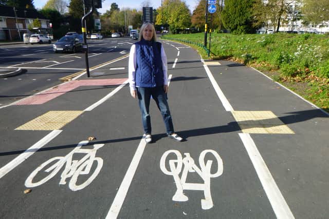 Cllr Deirdre Alden standing on black tarmac cycle lanes on Priory Road Edgbaston