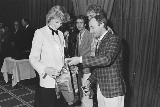 Diana, Princess of Wales (1961 - 1997) accepts a jacket with an embroidered gold crown for Prince William from British singer and drummer Phil Collins . (Photo by Steve Wood/Daily Express/Hulton Archive/Getty Images)