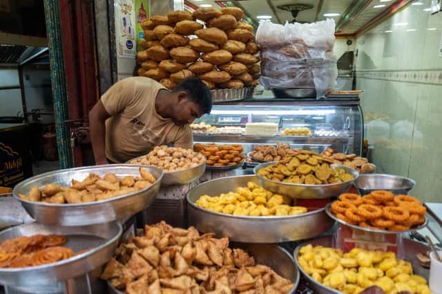 A shopkeeper arranges food to sell in Old Delhi  (Photo by JEWEL SAMAD/AFP via Getty Images)