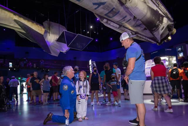 Bruce Melnick with a young child at Kennedy Space Center Visitor Complex (KSCVC) 
