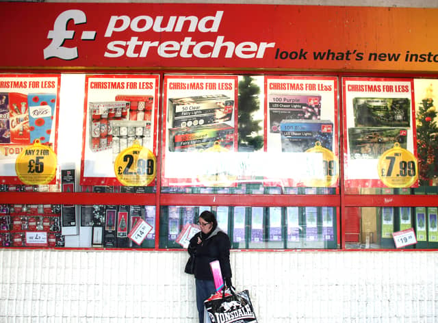 A woman waits outside a branch of Poundstretcher near Lewisham high street.